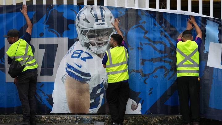Workers place a banner of Dallas Cowboys tight end Jake Ferguson at Maracana Stadium. Workers place a banner of Dallas Cowboys tight end Jake Ferguson at Maracana Stadium.
