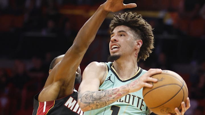 Mar 23, 2025; Miami, FL; LaMelo Ball rises above Andrew Wiggins for a layup during the first half at Kaseya Center