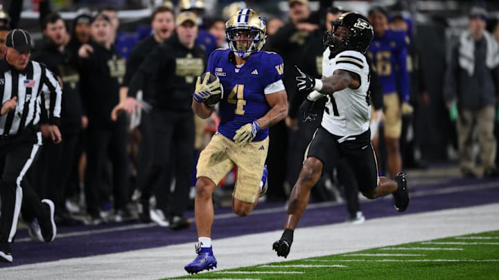 Nov 15, 2025; Seattle, Washington, USA; Washington Huskies running back Jordan Washington (4) carries the ball for a 68 yard touchdown while Purdue Boilermakers defensive back Tahj Ra-El (21) chases during the first half at Husky Stadium. Mandatory Credit: Steven Bisig-Imagn Images