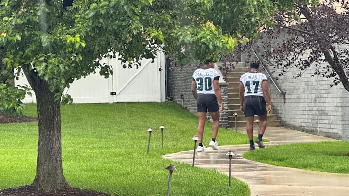 Eagles linebackers Jihaad Campbell and Nakobe Dean work their way through the rain as the Eagles' OTA practice began. The two injured players were on their way to likely receive rehab, returning after the OTA practice was about half over on May 28, 2025.
