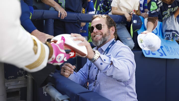 Oct 6, 2024; Seattle, Washington, USA; Seattle Seahawks general manager John Schneider signs autographs during pregame warmups against the New York Giants at Lumen Field. Mandatory Credit: Joe Nicholson-Imagn Images