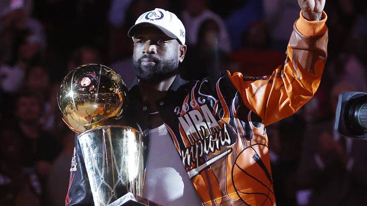 Former Miami Heat guard Dwayne Wade holds the Larry O' Brien trophy