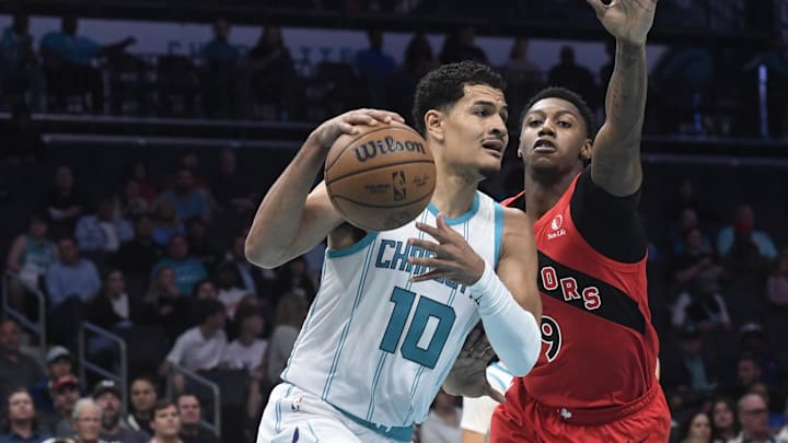 Oct 30, 2024; Charlotte, North Carolina, USA; Charlotte Hornets guard Josh Green (10) drives past Toronto Raptors guard forward RJ Barrett (9) during the first half at the Spectrum Center. Mandatory Credit: Sam Sharpe-Imagn Images