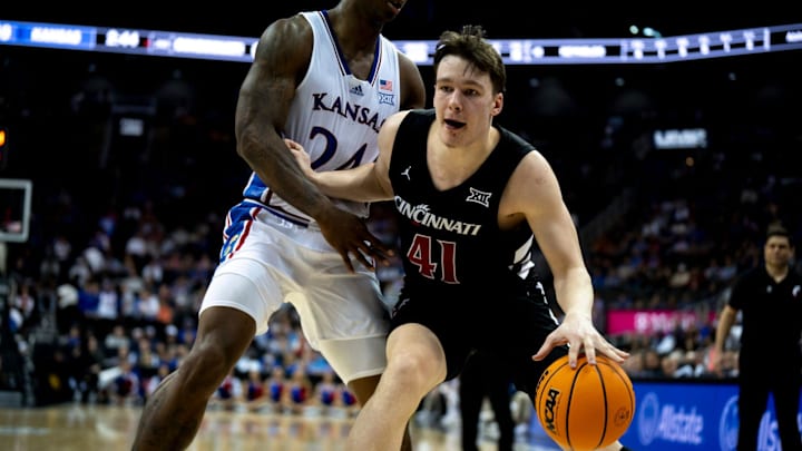 Cincinnati Bearcats guard Simas Lukosius (41) handles the ball as Kansas Jayhawks forward K.J. Adams Jr. (24) guards him in the second half of the Big 12 Conference tournament game between Cincinnati Bearcats and Kansas Jayhawks at T-Mobile Center in Kansas City, Mo., on Wednesday, March 13, 2024.