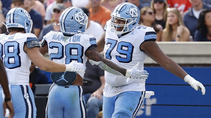 Oct 26, 2024; Charlottesville, Virginia, USA; North Carolina Tar Heels running back Omarion Hampton (28) celebrates with Tar Heels offensive lineman Howard Sampson (79) after scoring a touchdown against the Virginia Cavaliers during the first half at Scott Stadium. Mandatory Credit: Geoff Burke-Imagn Images