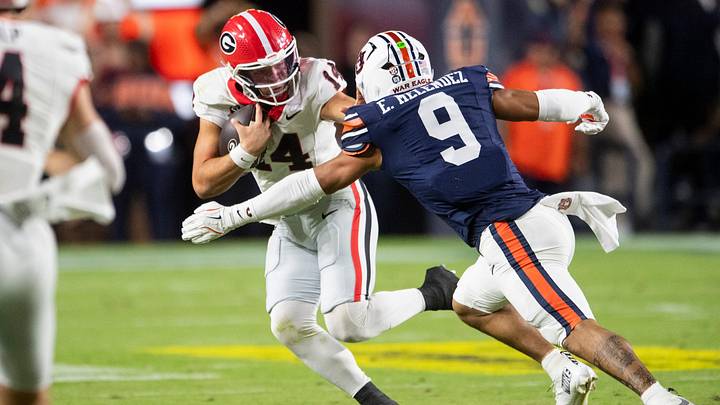 Georgia Bulldogs quarterback Gunner Stockton (14) attempts a stiff arm on Auburn Tigers linebacker Elijah Melendez (9) as Auburn Tigers take on Georgia Bulldogs at Jordan-Hare Stadium in Auburn, Ala. on Saturday, Oct. 11, 2025. Georgia Bulldogs defeated Auburn Tigers 20-10. Georgia Bulldogs quarterback Gunner Stockton (14) attempts a stiff arm on Auburn Tigers linebacker Elijah Melendez (9) as Auburn Tigers take on Georgia Bulldogs at Jordan-Hare Stadium in Auburn, Ala. on Saturday, Oct. 11, 2025. Georgia Bulldogs defeated Auburn Tigers 20-10.