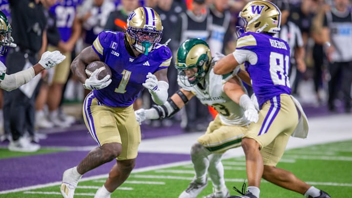 The UW's Jonah Coleman gets upfield with the help of a block from Dez Roebuck. 