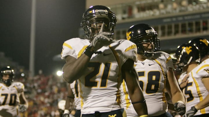 Sept 13, 2007; College Park, MD, USA; West Virginia defensive back Ryan Mundy (21) reacts to the crowd after quarterback Patrick White (5) scored a touchdown in the first quarter against the Maryland Terrapins at Chevy Chase Bank Field at Byrd Stadium.  West Virginia defeated Maryland 31-14.  Mandatory Credit: James Lang-Imagn Images Copyright © James Lang