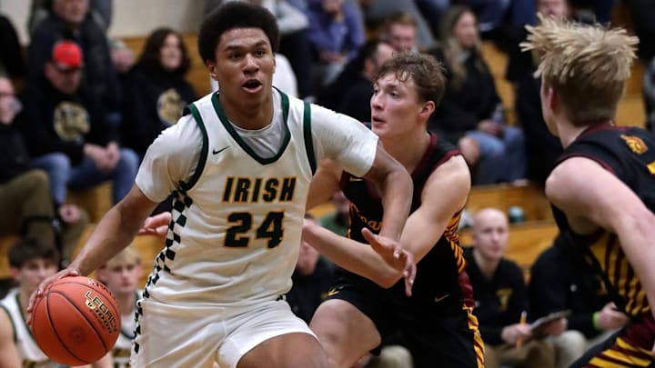Freedom High School's Donovan Davis (24) drives to the basket against Luxemburg-Casco High School's Mason Trimberger (12) and Tatem Klaubauf (1) during their boys basketball game Thursday, February 12, 2026, in Freedom. Freedom won 89-48.