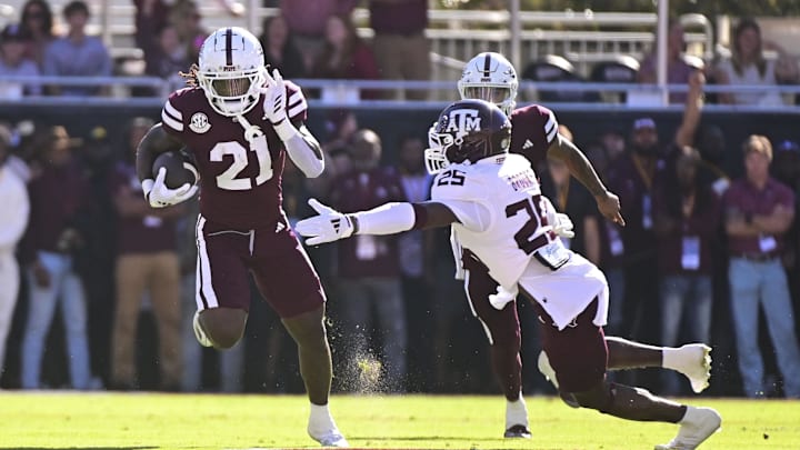 Oct 19, 2024; Starkville, Mississippi, USA; Mississippi State Bulldogs running back Davon Booth (21) runs the ball against Texas A&M Aggies defensive back Dalton Brooks (25) during the first quarter at Davis Wade Stadium at Scott Field. Mandatory Credit: Matt Bush-Imagn Images