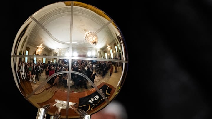 Aug 25, 2023; Washington, DC, USA; Attendees of a celebration of the Las Vegas Aces is reflected in the 2022 WNBA championship trophy in the East Room at The White House. Mandatory Credit: Josh Morgan-USA TODAY