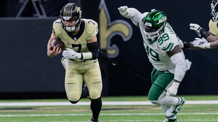 Dec 21, 2025; New Orleans, Louisiana, USA;  New York Jets defensive tackle Khalen Saunders (99) attempts to tackle New Orleans Saints tight end Taysom Hill (7) during the second half  at Caesars Superdome. Mandatory Credit: Stephen Lew-Imagn Images