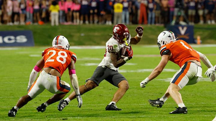 Oct 18, 2025; Charlottesville, Virginia, USA; Washington State Cougars running back Leo Pulalasi (20) runs with the ball as Virginia Cavaliers defensive back Donavon Platt (28) and Cavaliers linebacker James Jackson (1) chase in the third quarter at Scott Stadium. Mandatory Credit: Geoff Burke-Imagn Images