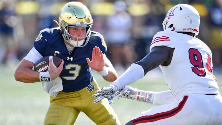 Sep 21, 2024; South Bend, Indiana, USA; Notre Dame Fighting Irish quarterback Riley Leonard (13) runs the ball as Miami Redhawks defensive end Josh Lukusa (94) defends in the second quarter at Notre Dame Stadium. Sep 21, 2024; South Bend, Indiana, USA; Notre Dame Fighting Irish quarterback Riley Leonard (13) runs the ball as Miami Redhawks defensive end Josh Lukusa (94) defends in the second quarter at Notre Dame Stadium.