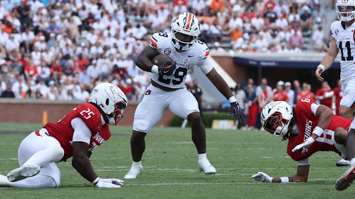 Sep 13, 2025; Auburn, Alabama, USA;  Auburn Tigers running back Omar Mabson II (29) carries between South Alabama Jaguars defenders during the third quarter at Jordan-Hare Stadium. Mandatory Credit: John Reed-Imagn Images