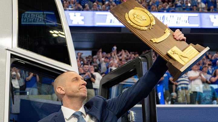 Mark Pope exits the bus with holding a trophy as he enters Rupp Arena greeting thousands of fans for his introductory press conference on Sunday, April 14, 2024.