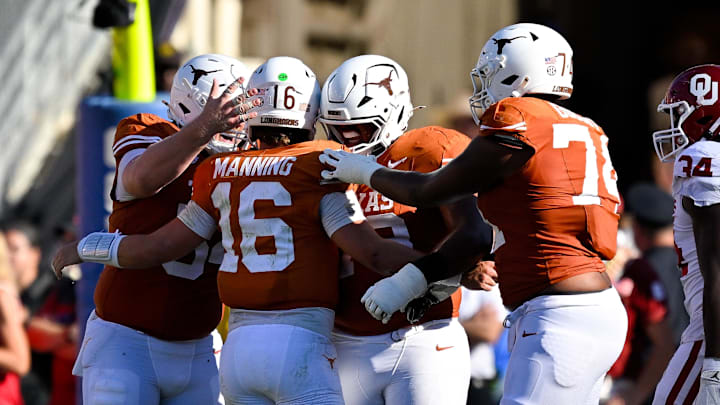 Texas Longhorns quarterback Arch Manning (16) celebrates with his lineman after he throws a touchdown against the Oklahoma Sooners during the second half at the Cotton Bowl.