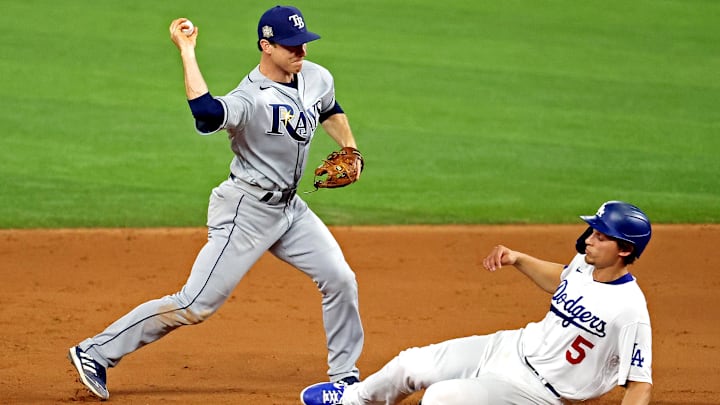 Oct 27, 2020; Arlington, Texas, USA; Tampa Bay Rays third baseman Joey Wendle (18) turns a double play over Los Angeles Dodgers shortstop Corey Seager (5) during the eighth inning during game six of the 2020 World Series at Globe Life Field. Mandatory Credit: Kevin Jairaj-Imagn Images