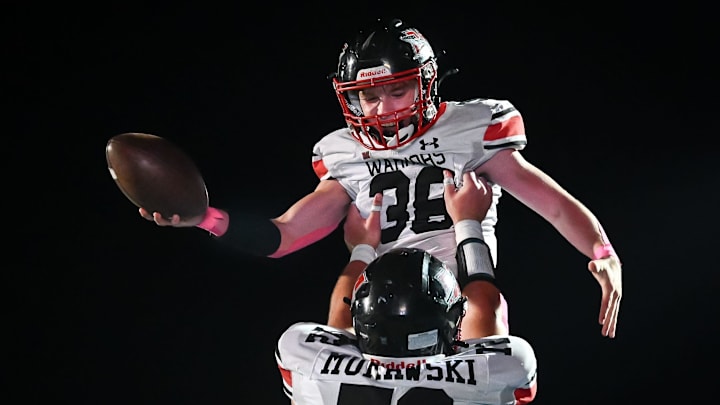 Muskego offensive lineman Parker Murawski (72) hoists fullback Bryson Hoeffler (38) after his touchdown run against Mukwonago in Classic 8 Conference game on Friday, October 17, 2025.