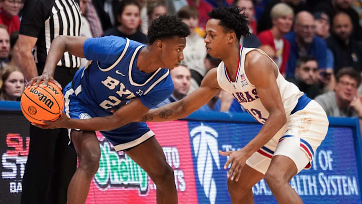 Feb 27, 2024; Lawrence, Kansas, USA; Brigham Young Cougars guard Jaxson Robinson (2) controls the ball as Kansas Jayhawks guard Elmarko Jackson (13) defends during the second half at Allen Fieldhouse. Mandatory Credit: Denny Medley-Imagn Images