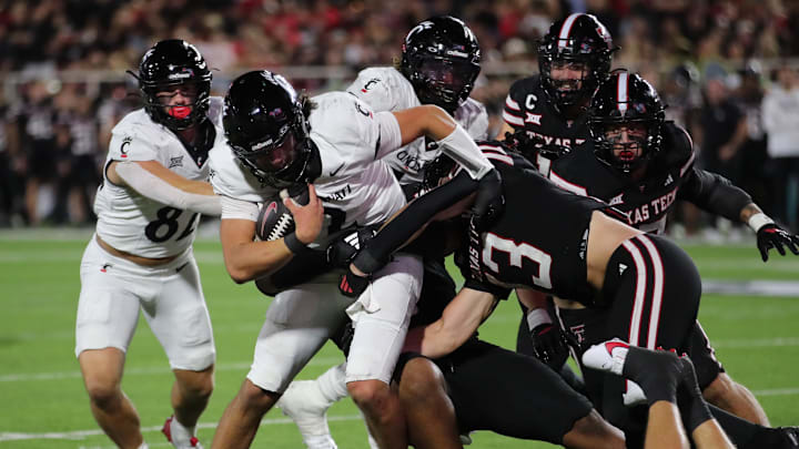 Sep 28, 2024; Lubbock, Texas, USA;  Cincinnati Bearcats quarterback Brendan Sorsby (2) is tackled by Texas Tech Red Raiders defensive back Ben Roberts (13) in the second half at Jones AT&T Stadium and Cody Campbell Field. Mandatory Credit: Michael C. Johnson-Imagn Images