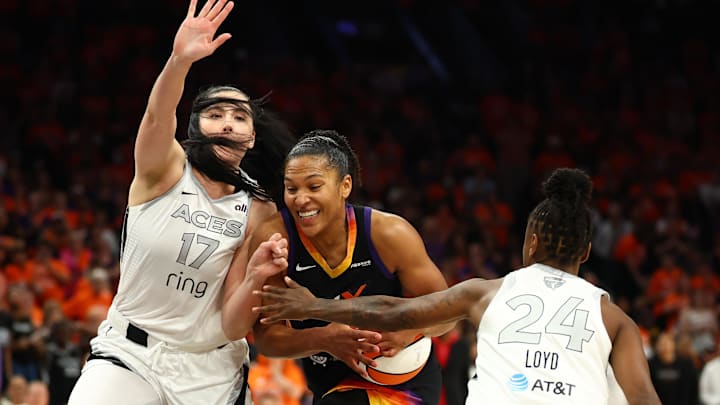 Oct 8, 2025; Phoenix, Arizona, USA;Phoenix Mercury forward Alyssa Thomas (25) dribbles past Las Vegas Aces center Megan Gustafson (17) and guard Jewell Loyd (24) in the second half during game three of the 2025 WNBA Finals at PHX Arena. Mandatory Credit: Mark J. Rebilas-Imagn Images