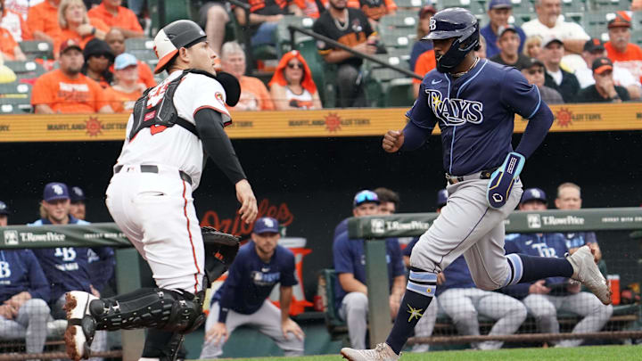 Sep 25, 2025; Baltimore, Maryland, USA; Tampa Bay Rays designated hitter Yandy Diaz (2) scores during the third inning in front of Baltimore Orioles catcher Alex Jackson (70) at Oriole Park at Camden Yards. 