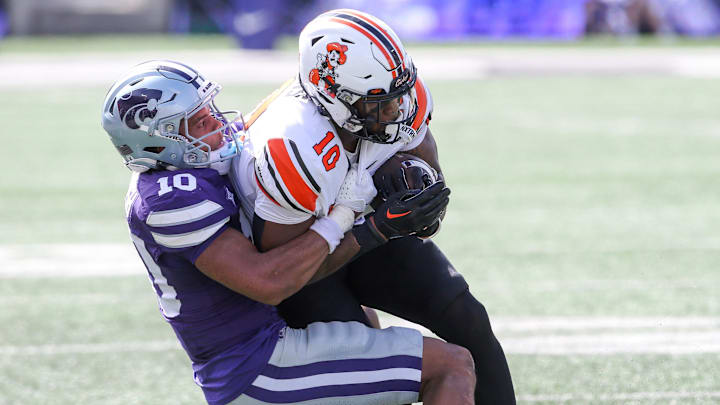 Sep 28, 2024; Manhattan, Kansas, USA; Oklahoma State Cowboys wide receiver Rashod Owens (10) is brought down by Kansas State Wildcats cornerback Jacob Parrish (10) during the second quarter at Bill Snyder Family Football Stadium
