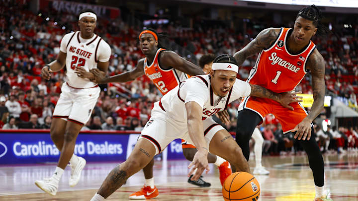 Jan 27, 2026; Raleigh, North Carolina, USA; NC State Wolfpack forward Darrion Williams (1) reaches for the ball guarded by Syracuse Orange forward Donnie Freeman (1) during the first half of the game at Lenovo Center. Mandatory Credit: Jaylynn Nash-Imagn Images