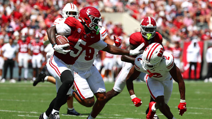 Sep 13, 2025; Tuscaloosa, Alabama, USA; Alabama Crimson Tide wide receiver Germie Bernard (5) avoids a tackle by Wisconsin Badgers cornerback Ricardo Hallman (2) during the second quarter at Saban Field at Bryant-Denny Stadium. Mandatory Credit: David Leong-Imagn Images