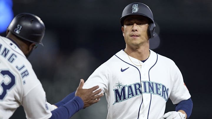 Apr 21, 2026; Seattle, Washington, USA; Seattle Mariners right fielder Rob Refsnyder (30) is greeted on first after a single against the Athletics during the third inning at T-Mobile Park. Mandatory Credit: John Froschauer-Imagn Images