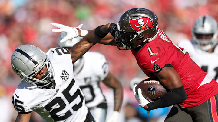 Dec 8, 2024; Tampa, Florida, USA; Tampa Bay Buccaneers running back Rachaad White (1) holds off Las Vegas Raiders cornerback Decamerion Richardson (25) in the third quarter at Raymond James Stadium. Mandatory Credit: Nathan Ray Seebeck-Imagn Images