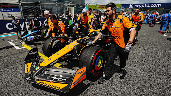 May 4, 2024; Miami Gardens, Florida, USA; Crewmembers push the car of McLaren driver Lando Norris (4) on the grid before the F1 Sprint Race at Miami International Autodrome. Mandatory Credit: John David Mercer-Imagn Images