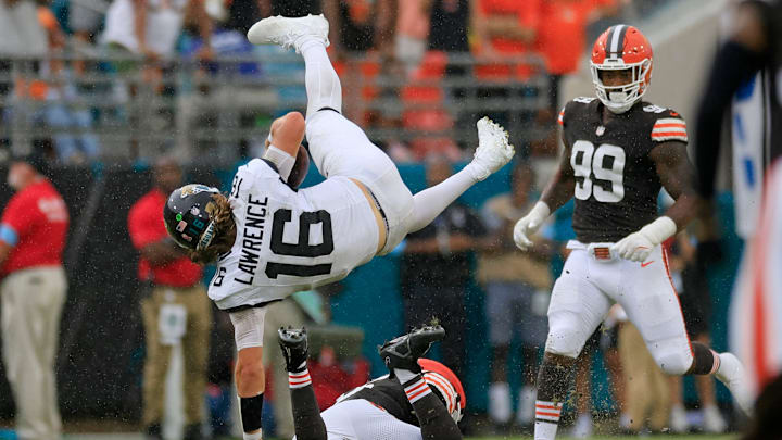 Jacksonville Jaguars quarterback Trevor Lawrence (16) is upended by Cleveland Browns linebacker Jeremiah Owusu-Koramoah (6) as defensive end Za'Darius Smith (99) looks on during the fourth quarter of an NFL football matchup Sunday, Sept. 15, 2024 at EverBank Stadium in Jacksonville, Fla. The Browns defeated the Jaguars 18-13. [Corey Perrine/Florida Times-Union]
