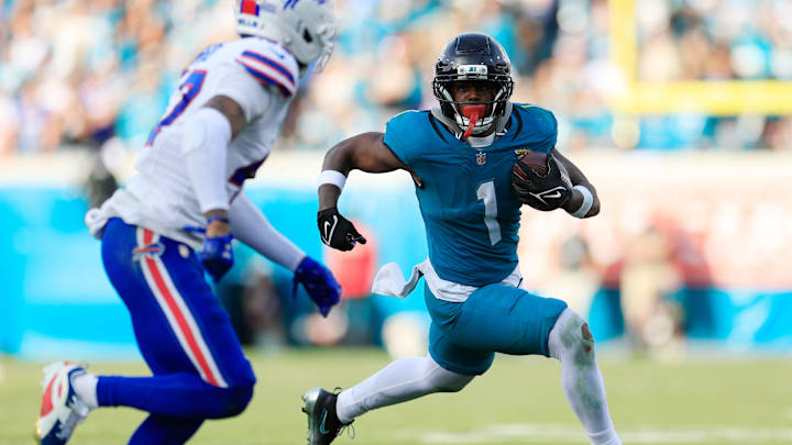 Jacksonville Jaguars running back Travis Etienne Jr. (1) rushes for yards against Buffalo Bills cornerback Christian Benford (47) during the fourth quarter of an NFL football AFC Wild Card playoff matchup, Sunday, Jan. 11, 2026, in Jacksonville, Fla. The Bills defeated the Jaguars 27-24. [Corey Perrine/Florida Times-Union]