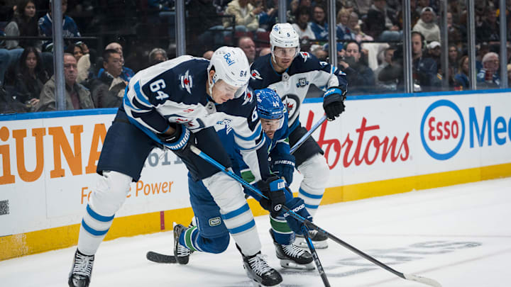 Nov 11, 2025; Vancouver, British Columbia, CAN; Winnipeg Jets defenseman Luke Schenn (5) watches as defenseman Logan Stanley (64) battles with Vancouver Canucks forward Kiefer Sherwood (44) in the second period at Rogers Arena. Mandatory Credit: Bob Frid-Imagn Images
