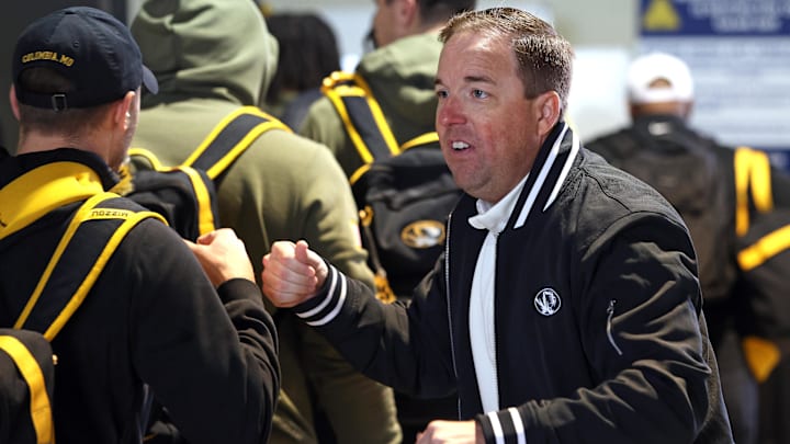 Nov 29, 2025; Fayetteville, Arkansas, USA; Missouri Tigers head coach Eli Drinkwitz greets players and staff as they enter the locker room prior to the game against the Arkansas Razorbacks at Donald W. Reynolds Razorback Stadium. Mandatory Credit: Nelson Chenault-Imagn Images