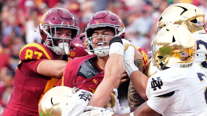 Nov 30, 2024; Los Angeles, California, USA; Southern California Trojans quarterback Jayden Maiava (14) scores on a 1-yard touchdown run against the Notre Dame Fighting Irish in the first half at United Airlines Field at Los Angeles Memorial Coliseum. Nov 30, 2024; Los Angeles, California, USA; Southern California Trojans quarterback Jayden Maiava (14) scores on a 1-yard touchdown run against the Notre Dame Fighting Irish in the first half at United Airlines Field at Los Angeles Memorial Coliseum.