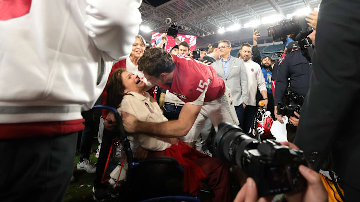 Jan 19, 2026; Miami Gardens, FL, USA; Indiana Hoosiers quarterback Fernando Mendoza (15) hugs his mother, Elsa Mendoza, after the College Football Playoff National Championship game against the Miami Hurricanes at Hard Rock Stadium. Mandatory Credit: Sam Navarro-Imagn Images
