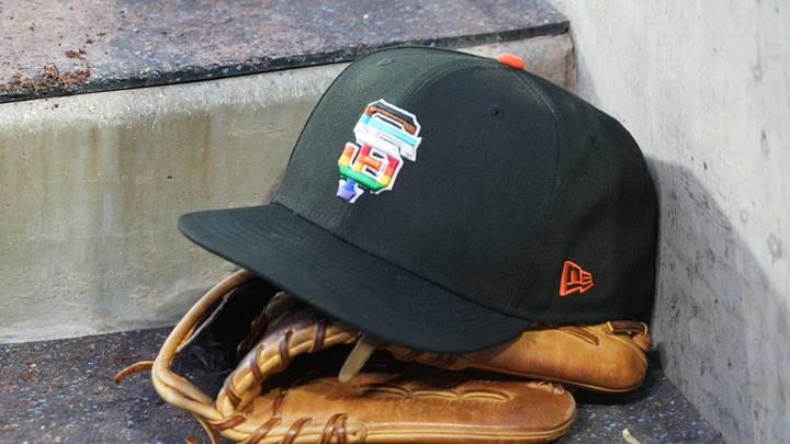 Jun 16, 2023; Los Angeles, California, USA; A rainbow colored San Francisco Giants logo cap and a glove in the dugout during LGBTQ+ Pride Night at Dodger Stadium at Dodger Stadium. Mandatory Credit: Kirby Lee-USA TODAY Sports