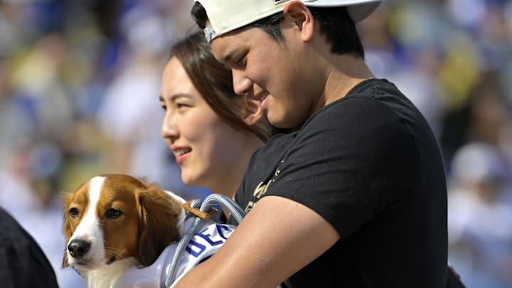 Nov 1, 2024: Los Angeles Dodgers designated hitter Shohei Ohtani holds his dog Decoy, as he walks off the field with his wife Mamiko Tanaka.
