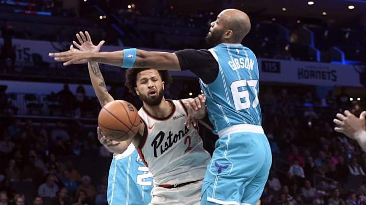 Nov 21, 2024; Charlotte, North Carolina, USA;  Detroit Pistons guard Cade Cunningham (2) passes as he is defended by Charlotte Hornets center Taj Gibson (67) during the first half at the Spectrum Center. Mandatory Credit: Sam Sharpe-Imagn Images