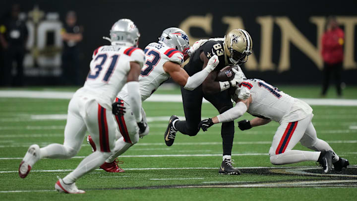 New England Patriots linebackers Christian Elliss (53) and linebacker Robert Spillane combine to tackle New Orleans Saints tight end Juwan Johnson.