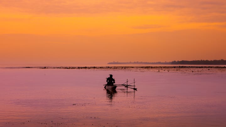 Man on a canoe on the sea, New Ireland Province, Kavieng, Papua New Guinea...