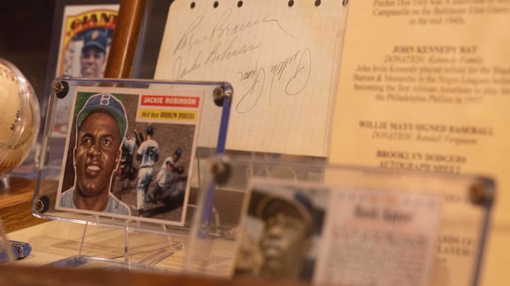 Oct 5, 2021; Kansas City, Missouri, USA; Baseball memorabilia, including a Hank Aaron card from 1962 from his sixth season with the Oakland Braves and a Jackie Robinson baseball card from his time at the Brooklyn Dodgers, are displayed alongside autographs and bats in the Negro Leagues Baseball Museum Oct 5, 2021; Kansas City, Missouri, USA; Baseball memorabilia, including a Hank Aaron card from 1962 from his sixth season with the Oakland Braves and a Jackie Robinson baseball card from his time at the Brooklyn Dodgers, are displayed alongside autographs and bats in the Negro Leagues Baseball Museum