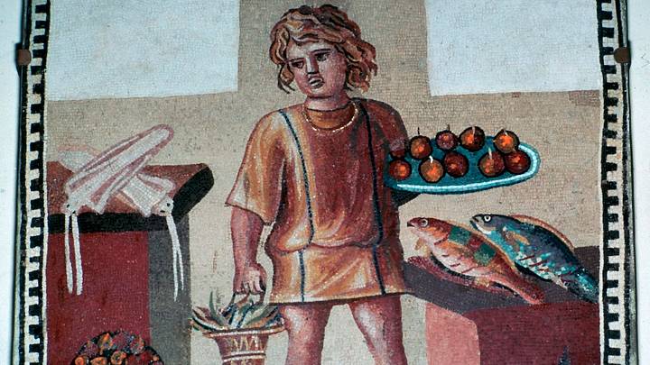 A Roman mosaic from Pompeii depicting an enslaved boy in a kitchen with fruit and fish. A Roman mosaic from Pompeii depicting an enslaved boy in a kitchen with fruit and fish.
