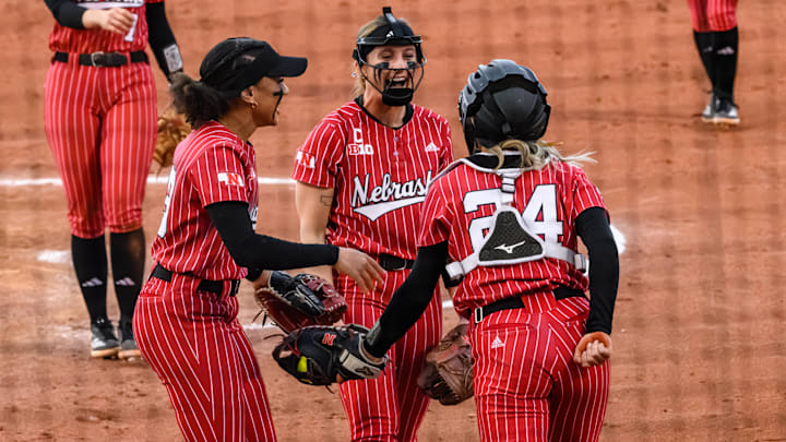 Samantha Bland (left), Jordy Bahl (middle) and Ava Bredwell (24) celebrate Bredwell's diving catch in the infield. 