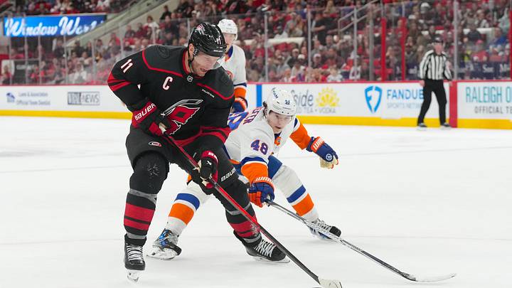 Apr 4, 2026; Raleigh, North Carolina, USA;  Carolina Hurricanes center Jordan Staal (11) skates with the puck against New York Islanders defenseman Matthew Schaefer (48) during the third period at Lenovo Center. Mandatory Credit: James Guillory-Imagn Images