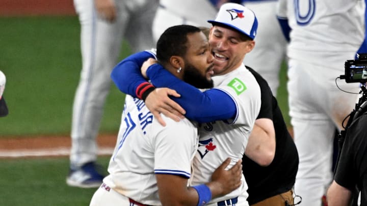 Toronto Blue Jays first baseman Vladimir Guerrero Jr. (27) and designated hitter George Springer (4) celebrate after winning game seven of the ALCS round for the 2025 MLB playoffs against the Seattle Mariners at Rogers Centre.