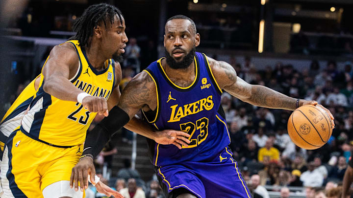 Mar 29, 2024; Indianapolis, Indiana, USA; Los Angeles Lakers forward LeBron James (23) dribbles the ball while Indiana Pacers forward Aaron Nesmith (23) defends in the second half at Gainbridge Fieldhouse. Mandatory Credit: Trevor Ruszkowski-Imagn Images